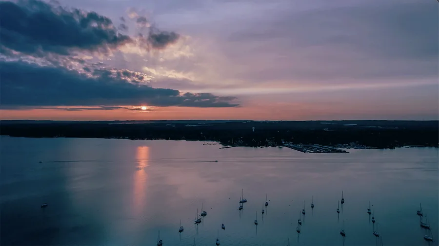 Aerial drone video frame of sailboats at sunset on a Maryland river